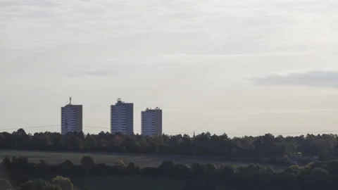 Colorful trees with three high rise buildings on a misty morning time lapse Stock Footage 220704060