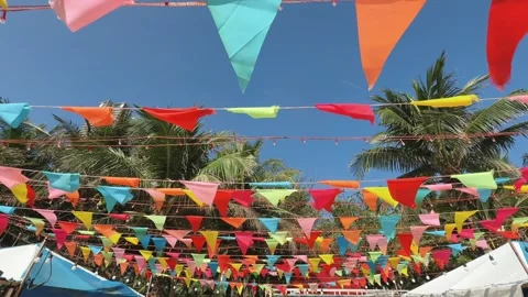 Colorful triangular bunting flags hanging over beach resort creating festive Stock Footage 341544349