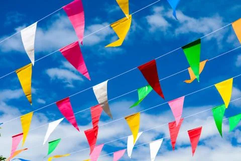 Colorful triangular flag line moving by wind on blue sky white cloud Stock Photos