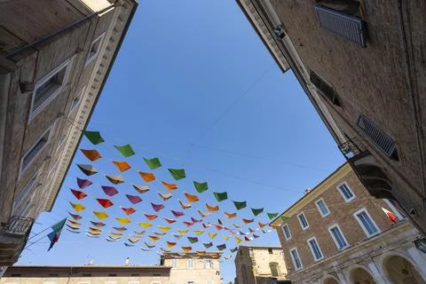 Colorful triangular flags are strung across a small square in Urbino, Italy Stock Photos
