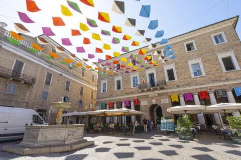 Colorful triangular flags are strung across a small square in Urbino, Italy Stock Photos