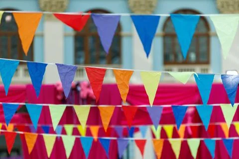 Colorful triangular flags hang in rows. Bright hues create a festive, cheer.. Stock Photos
