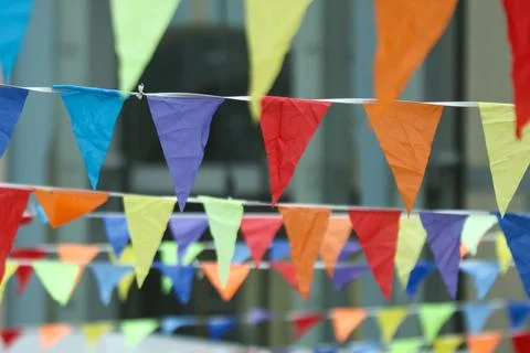 Colorful triangular flags hang in rows. Bright hues create festive, cheerfu.. Stock Photos