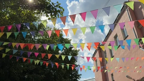 Colorful triangular flags hanging outdoors with blue sky and clouds in summ.. Stock Footage 342947329