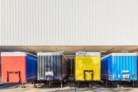Colorful truck trailers in front of the loading dock of a Dutch warehouse Stock Photos