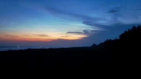 Colorful twilight clouds over dark coastal silhouette Stock Footage 335441064