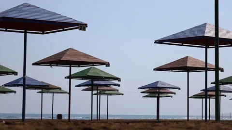 Colorful umbrellas on the coast of an empty beach Stock Footage 287135195
