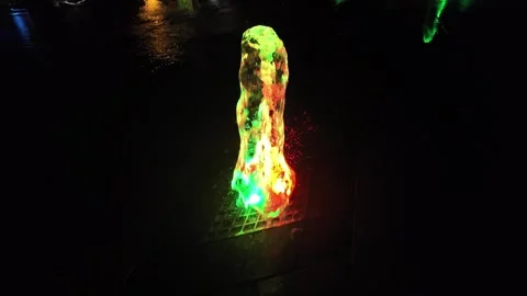 Colorful Water Streams Creating Mesmerizing Reflections in the City at Night Stock Footage 303980272