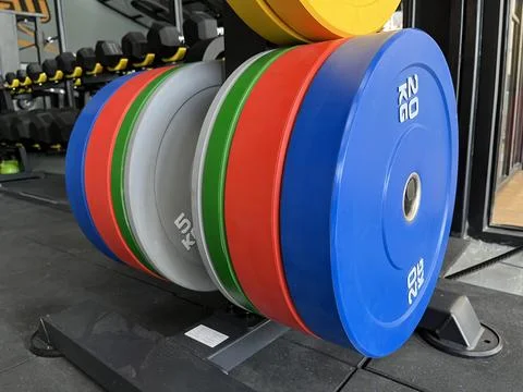 Colorful weight plates stack on a storage rack Stock Photos