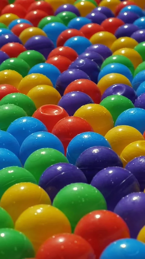 Colorful wet plastic balls floating in a pool Stock Footage 341446653