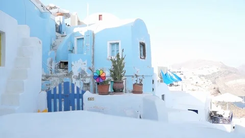 Colorful windmill moving in the front of a typical Greek building, Oia, Santo Stock Footage