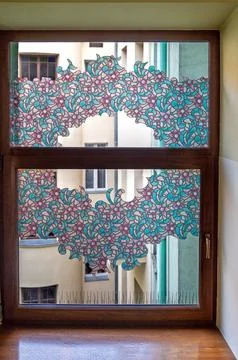 A colorful window design covers a frame with patterns and shapes in a buildin Stock Photos