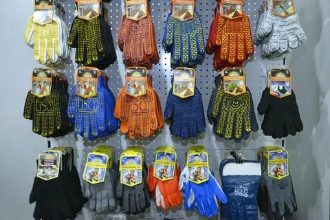 Colorful work gloves made by Intertool selling on a counter of a shop. Kyiv.. Stock Photos