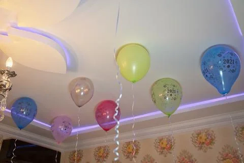 Colorfull balloons float on the white ceiling in the room for the party. Wedd Stock Photos