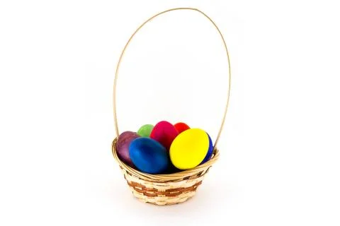 Colorfull Easter eggs in wicker basket isolated on white background Stock Photos