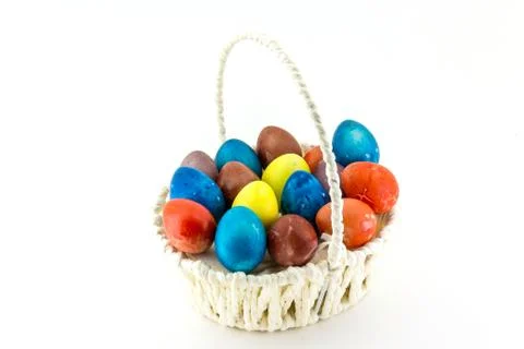 Colorfull Easter eggs in wicker basket isolated on white background Foto stock