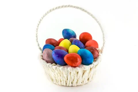 Colorfull Easter eggs in wicker basket isolated on white background Stock Photos