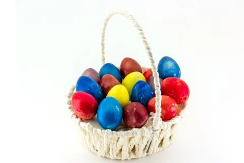 Colorfull Easter eggs in wicker basket isolated on white background Stock Photos