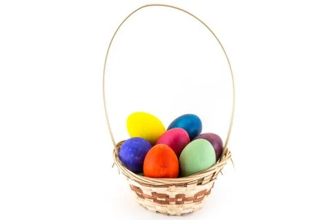 Colorfull Easter eggs in wicker basket isolated on white background Stock Photos