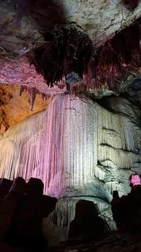 Colorfully Illuminated Flowstone Inside Limestone Cave Stock Photos