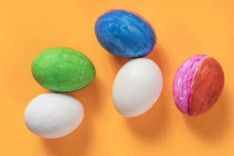 Colorfully painted Easter eggs are displayed against a bright orange backgr.. Stock Photos