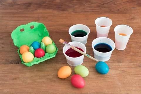 Coloring easter eggs with beautiful colors brush and paint cups. Handmade pas Stock Photos