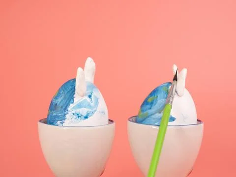 Coloring Easter eggs. Decorate eggs for Easter on a pink background. Stock Photos