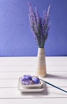 Coloring eggs with a brush. Easter tradition. Painted eggs on a white wooden Stock Photos