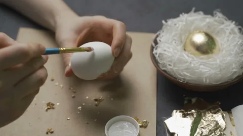 Coloring eggs for Easter with hands and a brush with watercolor paints. Stock Footage 104396025