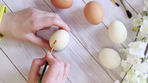 Coloring eggs, top view. Women's hands, prepare for Easter, draw on the egg Stock Footage 232994921