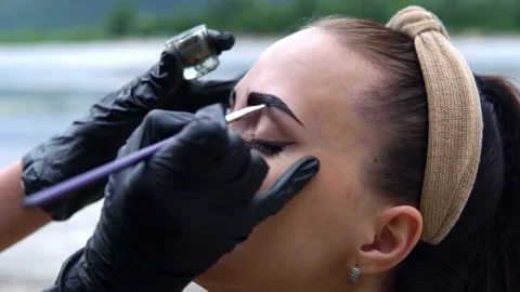 Coloring eyebrows on the banks of the river. Stock Footage 202010200