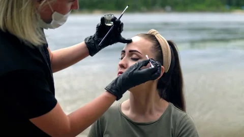 Coloring eyebrows on the banks of the river. Stock Footage 202010242