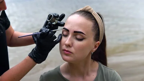 Coloring eyebrows on the banks of the river. Stock Footage 202010301
