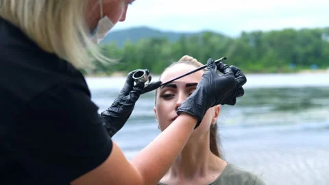 Coloring eyebrows on the banks of the river. Stock Footage 202010340