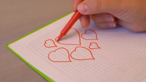 Coloring hearts in a notebook 4K Stock Footage 102438808