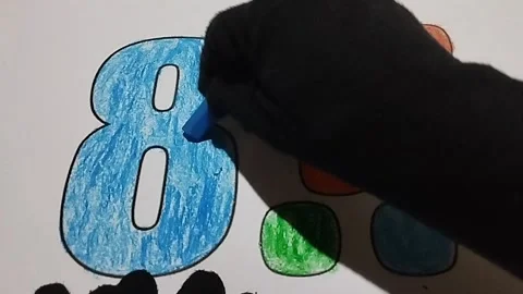 Coloring the number eight using a light blue crayon Stock Footage 224966529