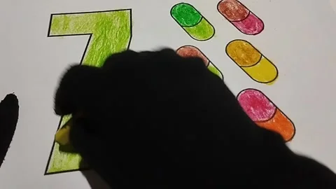 Coloring the number seven using a light green crayon Stock Footage 224967894
