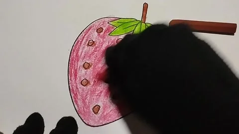 Coloring pictures of strawberries using red, brown and green crayons Stock Footage 224967069