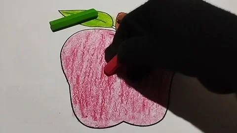 Coloring the shape of an apple using a red crayon Stock Footage 224978558