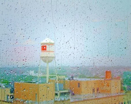 Colorized urban rooftops though a raindrop-covered window Stock Photos