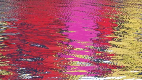 Colors reflected in rippled water surface - colorful red, pink and yellow wall Stock Footage 232104512