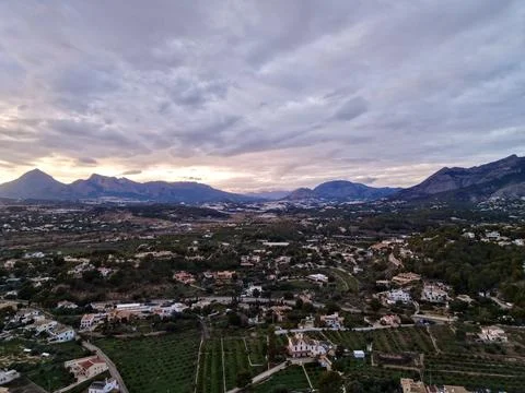 Colors of sunset underscore transition between city outskirts and neighboring Stock Photos
