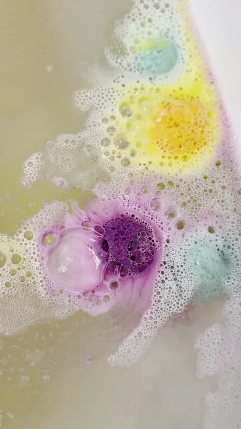 Colorufl bath bombs spin and fizz bubbles in bathtub Stock Footage 334763138