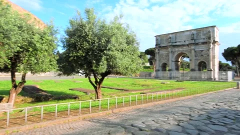 Colosseum area view of ancient tiled road and Constantine Arch Stock Footage 134091963