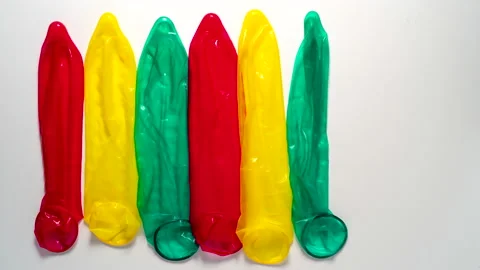 Colour condoms disappear from a white table, Stop motion Видео 169923980