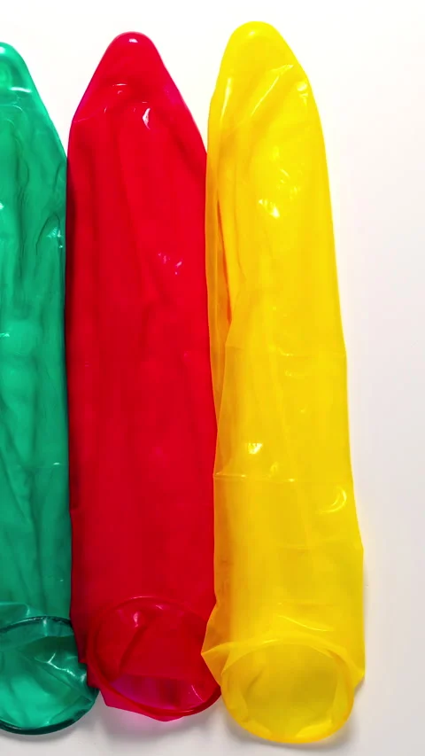 Colour condoms disappear from a white table, Stop motion Stock Footage 344860375