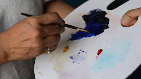 COLOUR ON PALETTE MIXED BY ELDERLY HAND Stock Footage 130945956