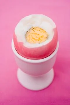 Coloured boiled egg in eggcup (with top cut off) Stock Photos