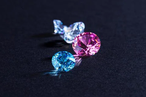Coloured diamonds of different sizes at the workplace of a diamond expert Stock Photos