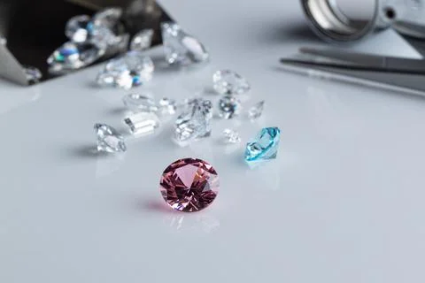 Coloured diamonds of different sizes at the workplace of a diamond expert Stock Photos